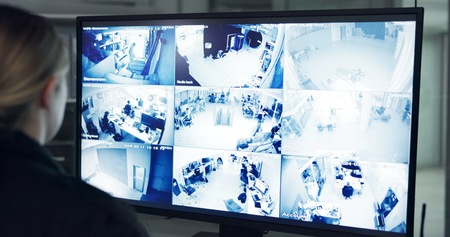 オフィスのマルチモニターで複数の監視カメラ映像をリアルタイムに確認するオペレーター