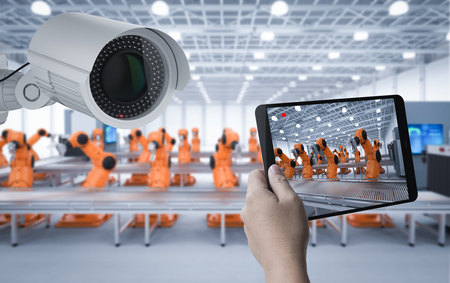 AR(拡張現実)技術を活用してタブレット越しに工場内の製造ラインとロボットを点検する様子
