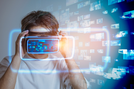 VRゴーグルを装着した人物と、背景に広がる多数のデジタルスクリーンや映像コンテンツ