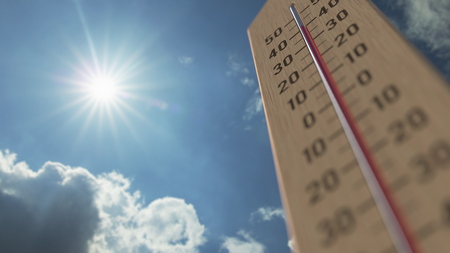 強い日差しと青空の下、35℃以上の高温を示す木製温度計