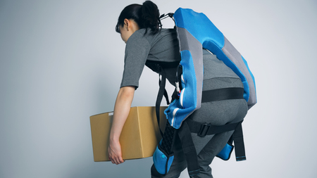アシストスーツを着て荷物を運ぶ女性
