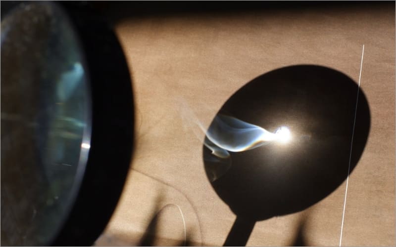 虫眼鏡で光を集める写真